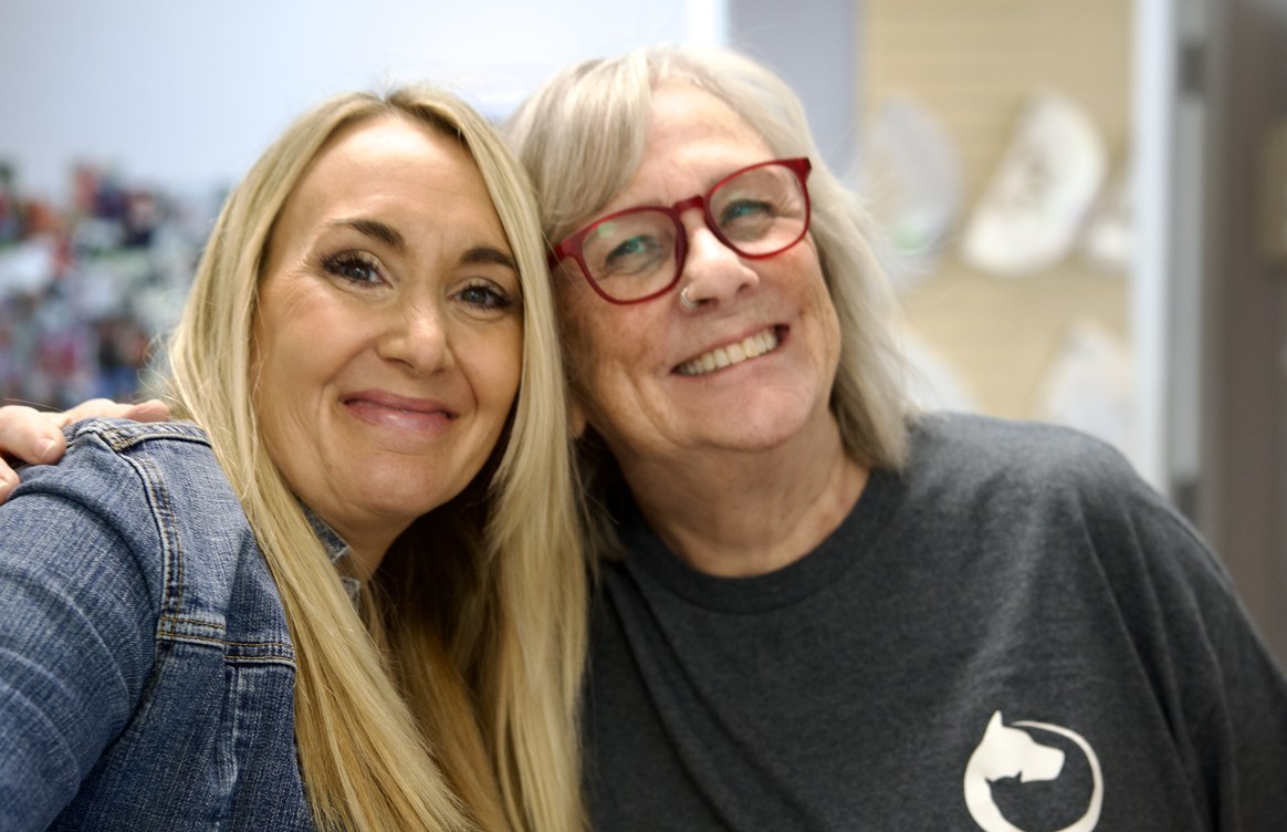 Two front-desk team members smiling together at the clinic