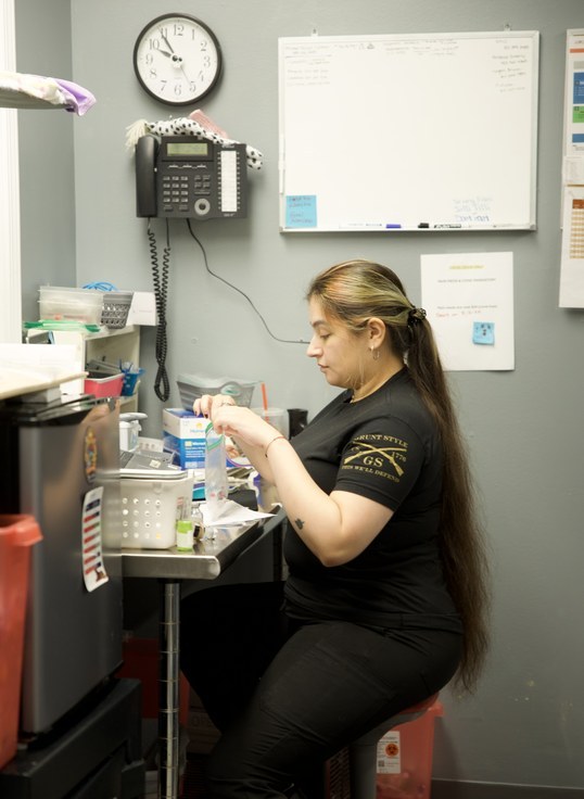 A team member carefully preparing medications in the treatment area