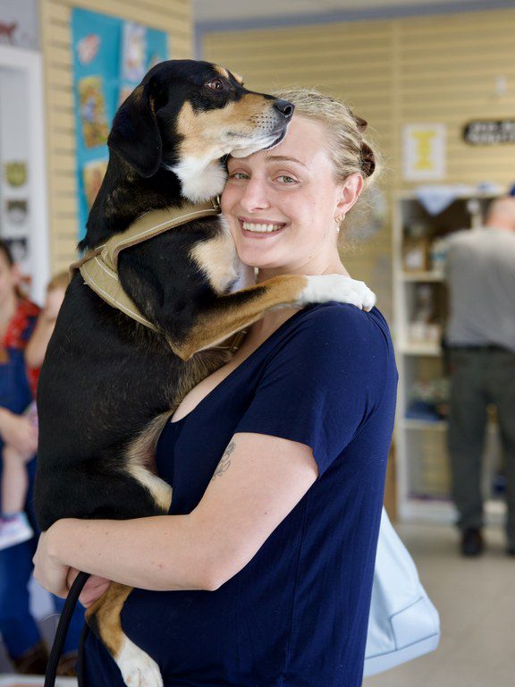 A happy client hugging her dog at the Pets Alive clinic