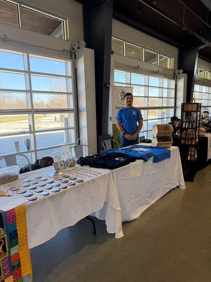 A Pets Alive volunteer staffing an outreach table at a community event